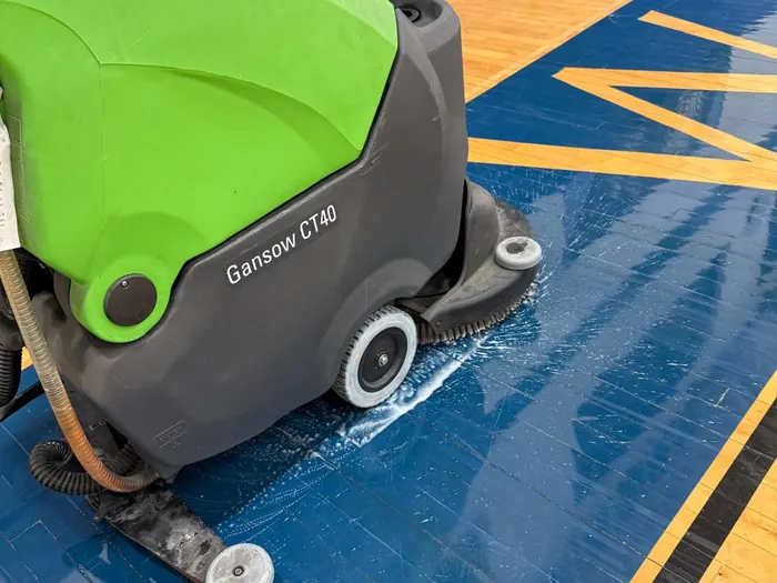 Máquina fregadora Gansow puliendo un piso deportivo azul